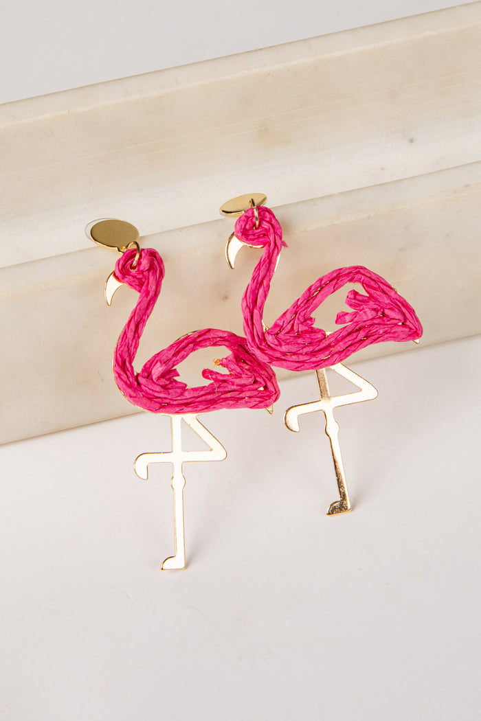 Flamingo-shaped earrings on a light background