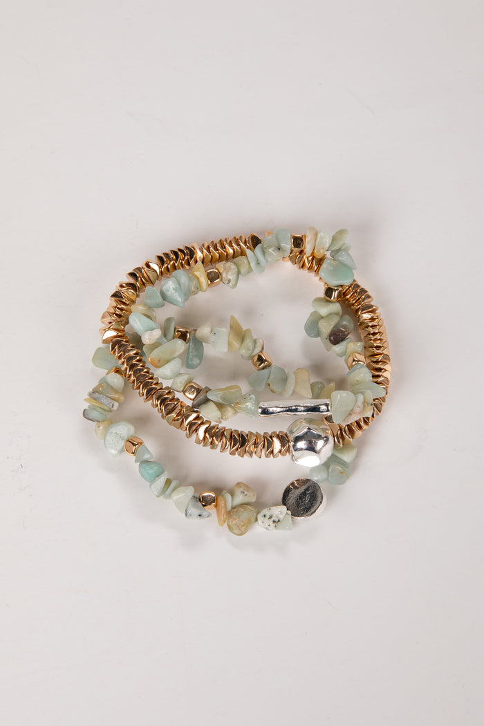 Set of beaded bracelets with gold accents on a light background