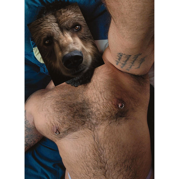 Queer collage postcard by Naro Pinosa overlapping a brown bear's face with a hairy male torso featuring pierced nipples and tattoos on both arms.