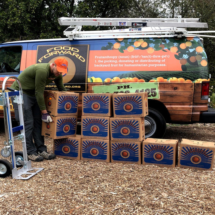 Orange marmalade donation boxes stacked beside a food-forward truck