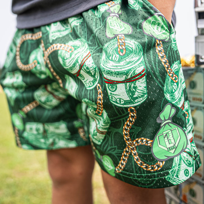 Person wearing green shorts with money and chain pattern outdoors.