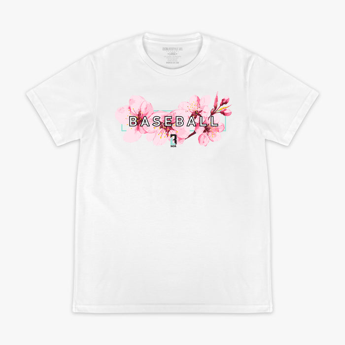 Person in a gray BL101 crewneck holding the black cherry blossom snapback hat to cover their face against a pink background with cherry blossoms in the background