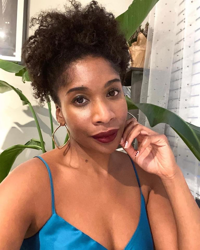 woman with curly hair wearing coffee red brown matte lipstick