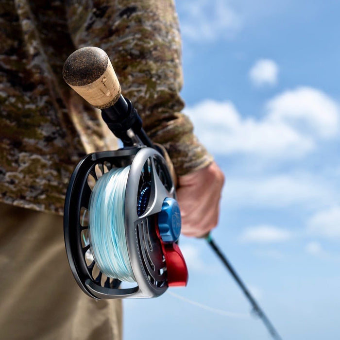 An angler holding up a fly fishing rod that is lined with Compact Intermediate