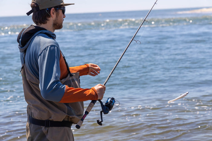 Angler holding onto his fishing pole and his lure is dangling up in the air.