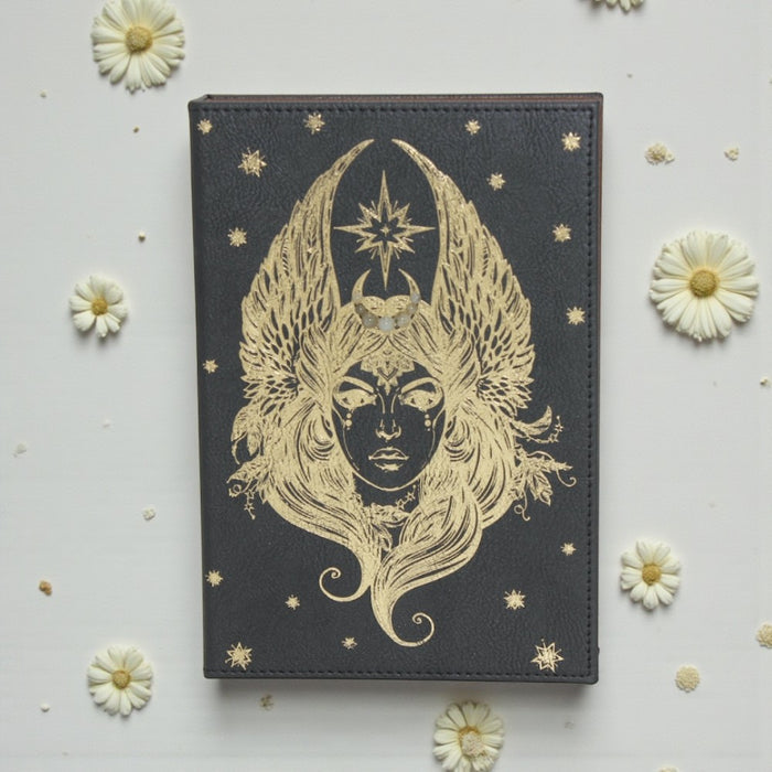 Earths Elements Goddess Journal on a light gray background with white flowers.