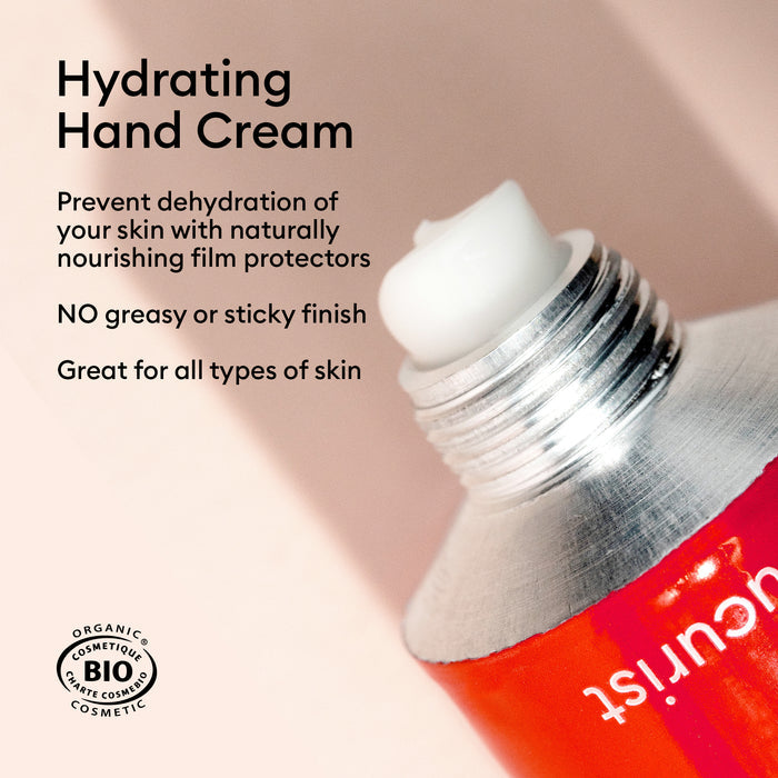 A close-up of an open tube of Manucurist Everyday Rose Hand Cream - Cosmos Organic on a light background, with text: prevents dehydration, no greasy finish, suitable for all skin types, and organic cosmetic certification.