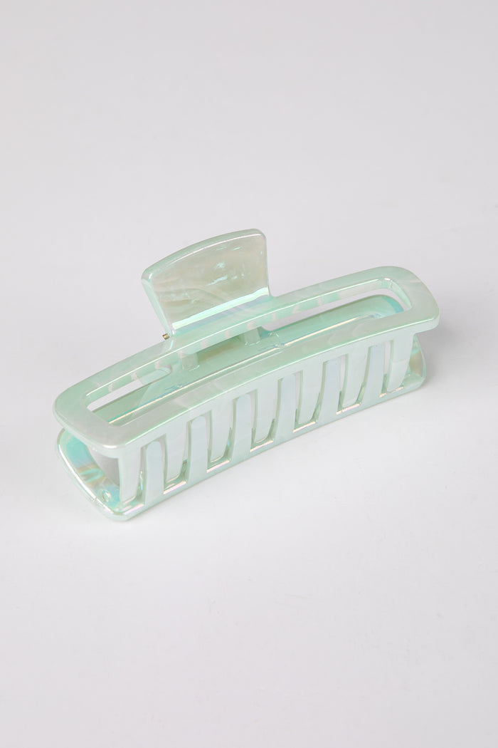 Mint green hair clip on a light gray background