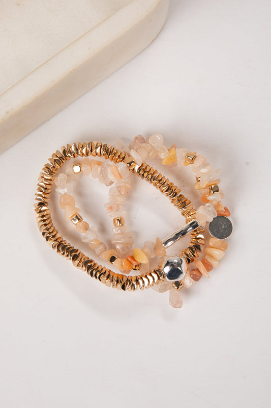 Set of beaded bracelets with gold and silver accents on a white surface