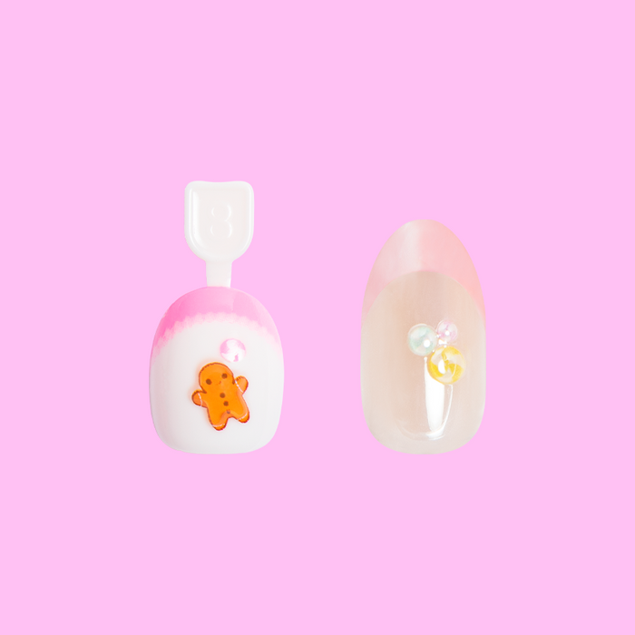 Gingerbread Set showing two press-on nails with pink, white, and clear bases featuring gingerbread and pearl accents manicure