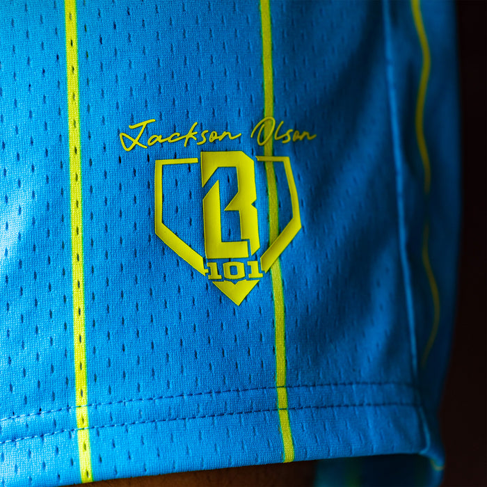 Blue shorts with yellow 'Jackson Olson BL101' logo and text on a dark background
