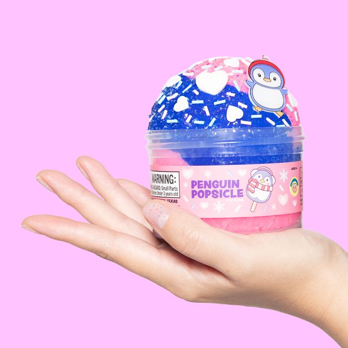 Paint & Play Slime + Nail Set showing hand holding Penguin Popsicle slime with winter-themed decorations and nail art stickers