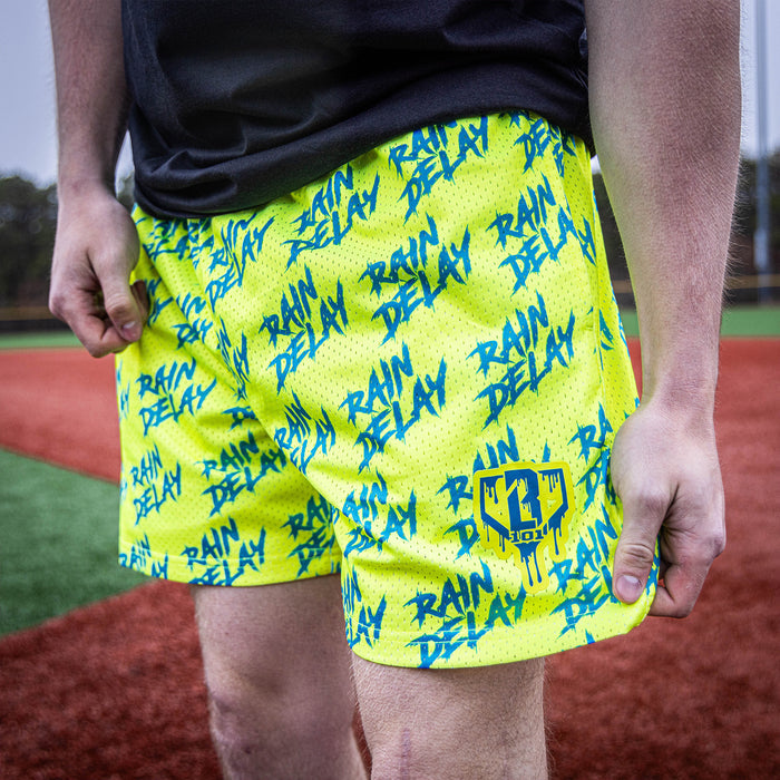 Youth model wearing yellow and blue Rain Delay youth shorts