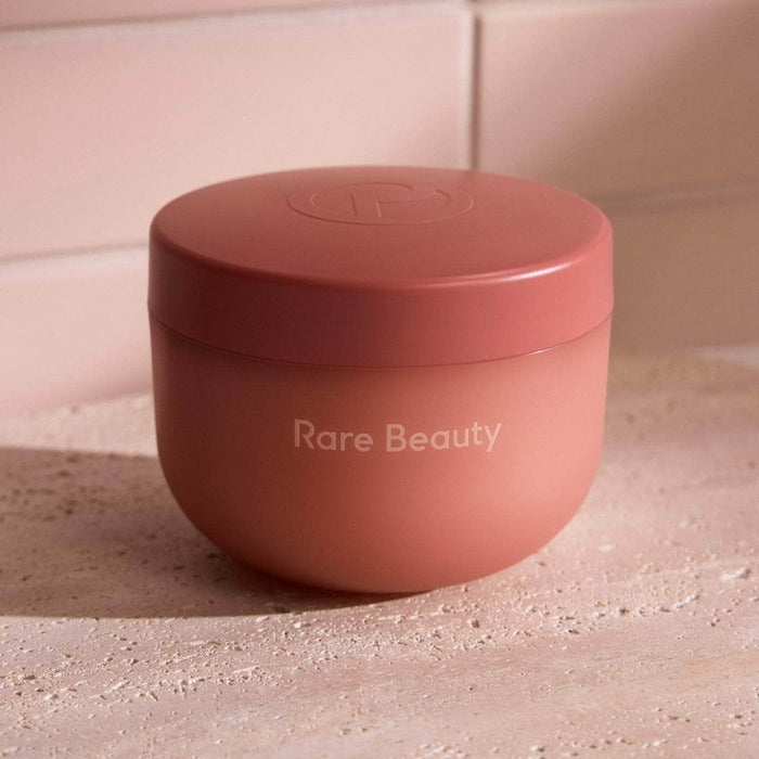 Rare Beauty Find Comfort Bouncy Body Cream with hyaluronic acid, shown in a sleek jar with a smooth, creamy texture.