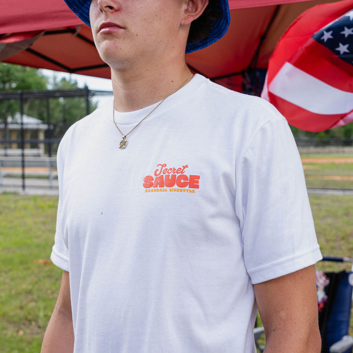 Person wearing a white t-shirt with 'Secret Sauce' logo outdoors