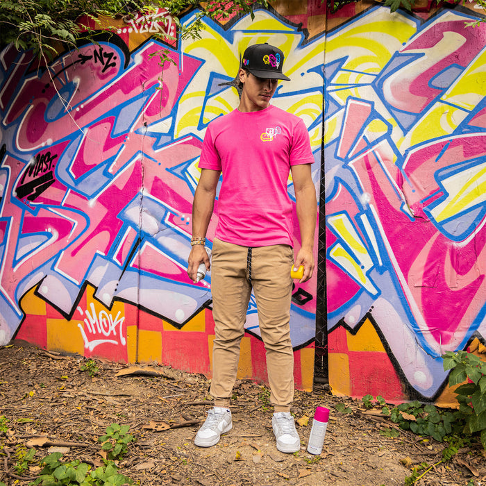 Adult model wearing pink graphic tee with “Smiley Slugger” design
