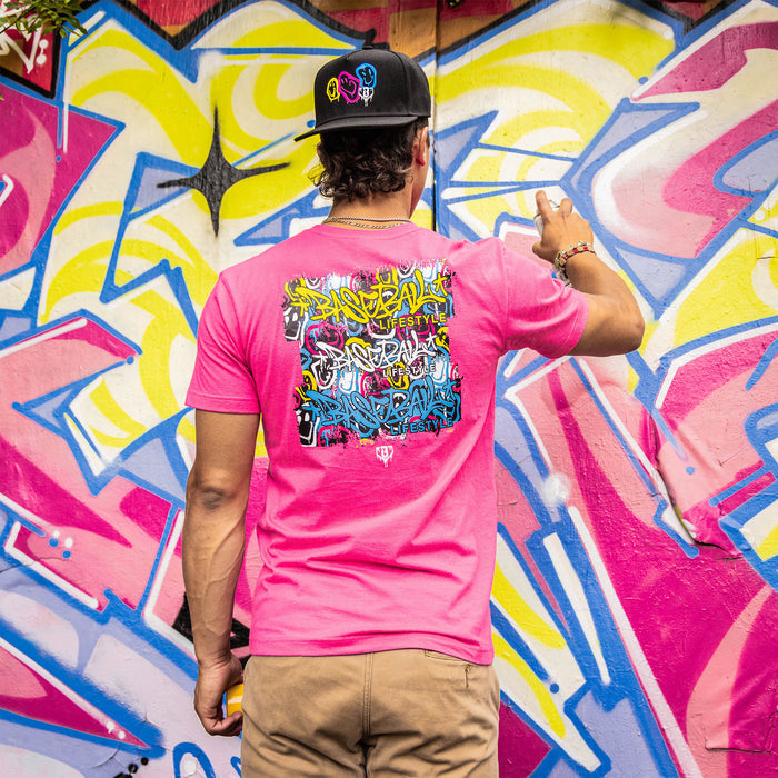 Adult model wearing pink graphic tee with “Smiley Slugger” design