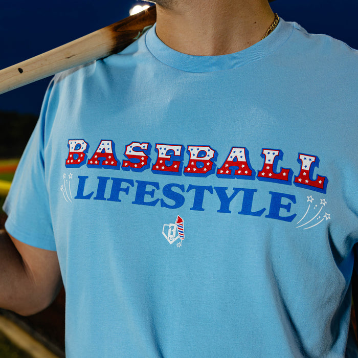 Light blue tee with patriotic red, white, and  blue Baseball Lifestyle firework sparkler graphic