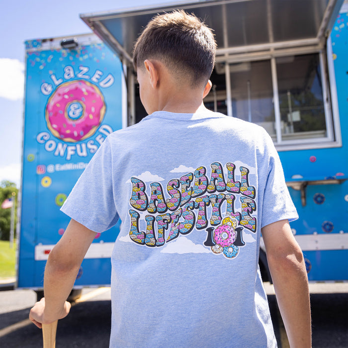 Youth model wearing blue youth graphic tee with “Sugar Rush Donut” design