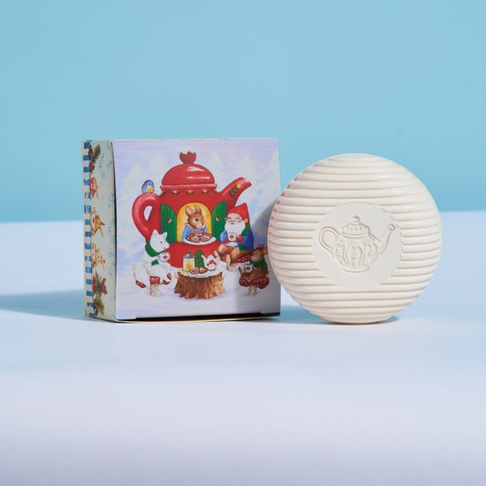 Round white soap bar with teapot emblem, shown with illustrated gnome gift box