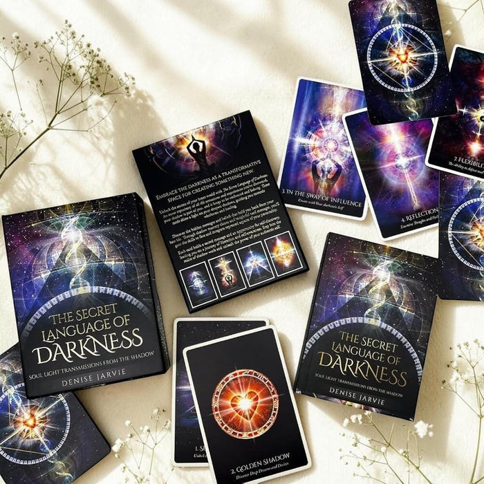 Tarot cards from 'The Secret Language of Darkness' by Denise Jarvis on a light surface with flowers.