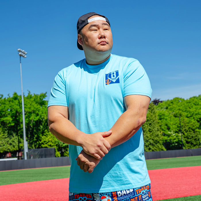 Adult model wearing blue graphic tee with "Trash Talk" design