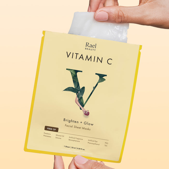 Model removing a Rael Vitamin C Brighten + Glow Face Sheet Masks from individually wrapped package.