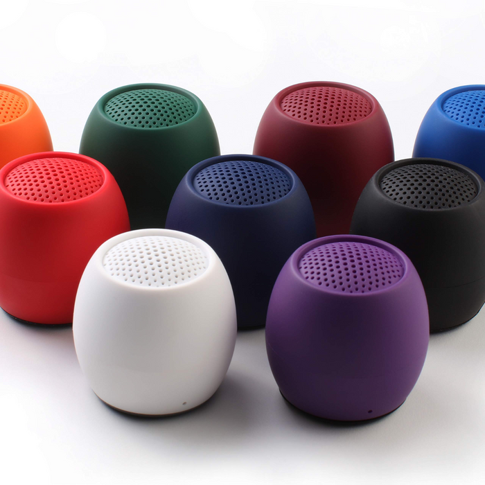 Mini wireless speakers in assorted colors: red, green, blue, white, purple, and black