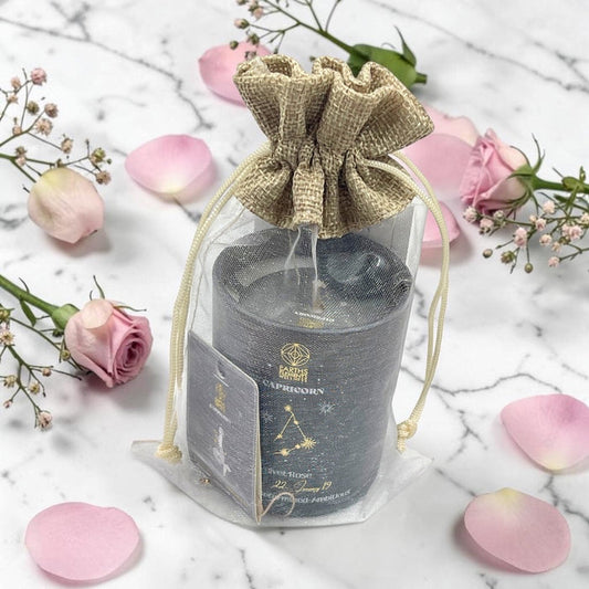Candle in a decorative bag with pink flowers on a marble surface